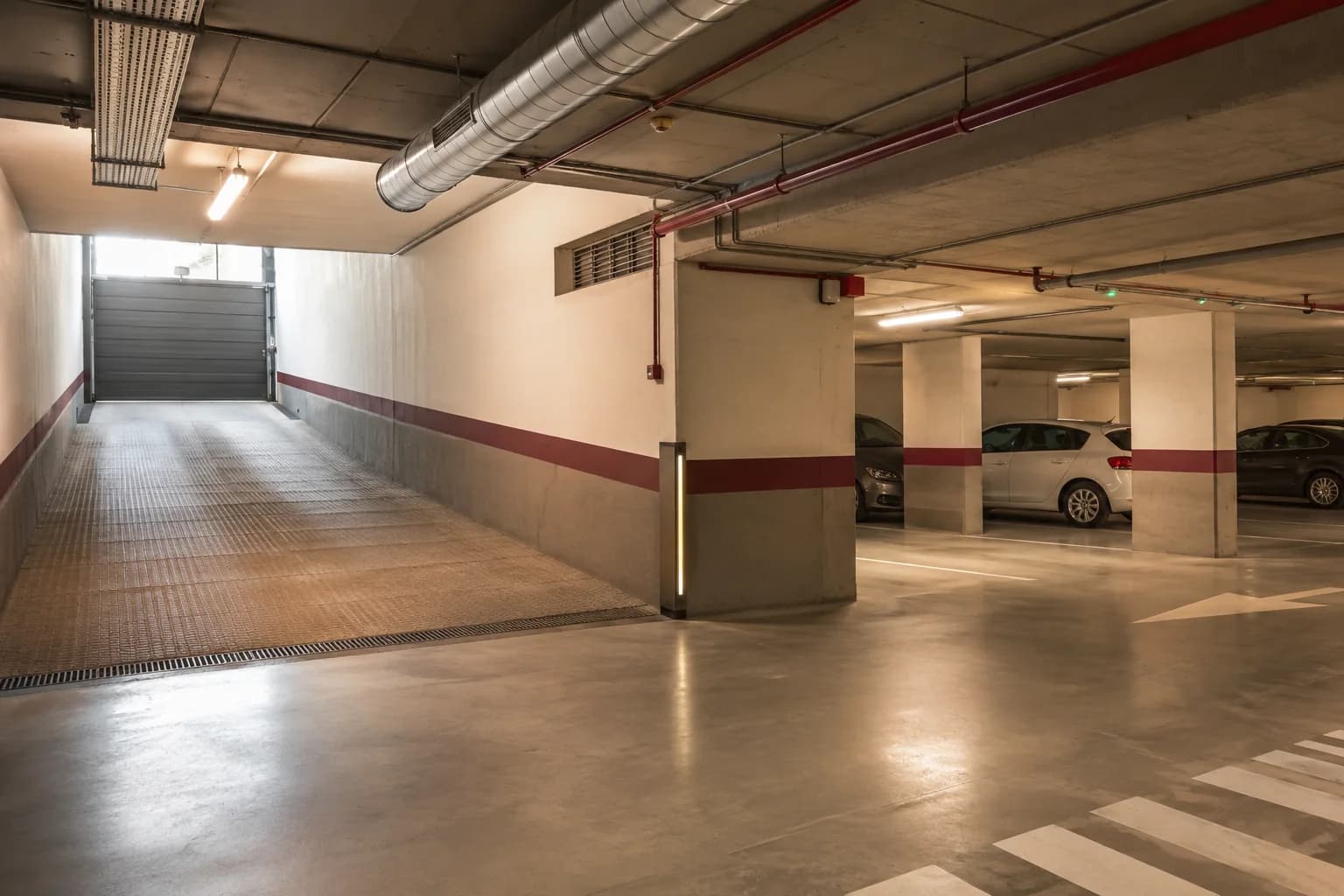 Garaje comunitario con puerta automática e iluminación arquitectónica